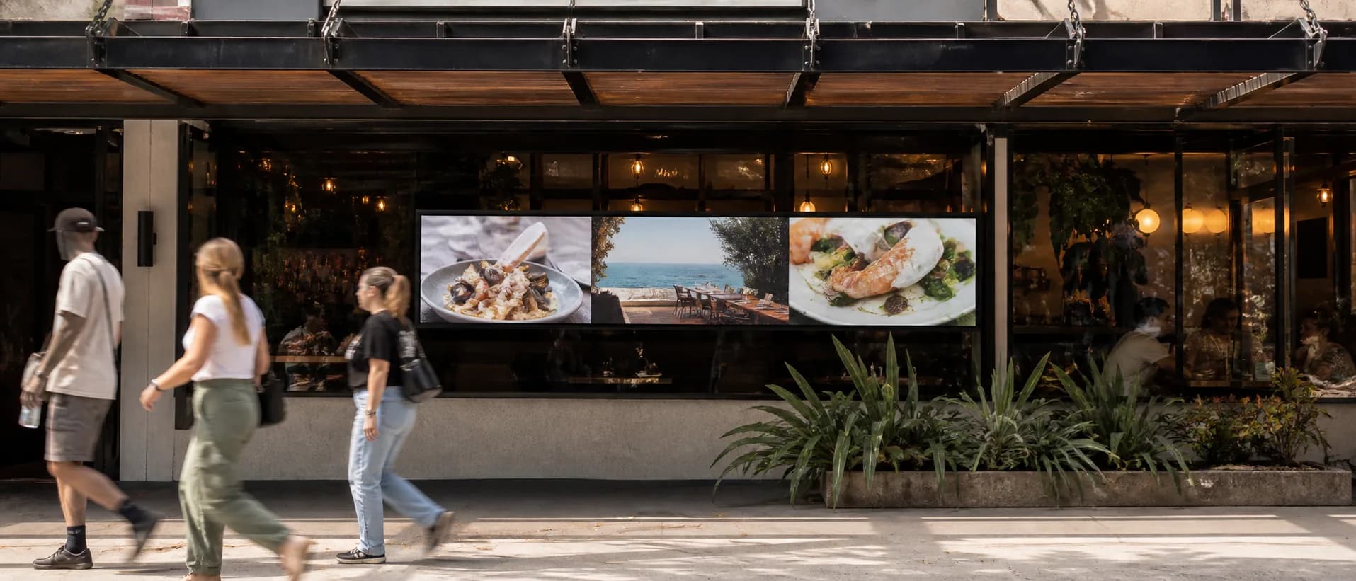 Outdoor-facing hospitality frontage with an ultrawide high brightness display visible from the pavement