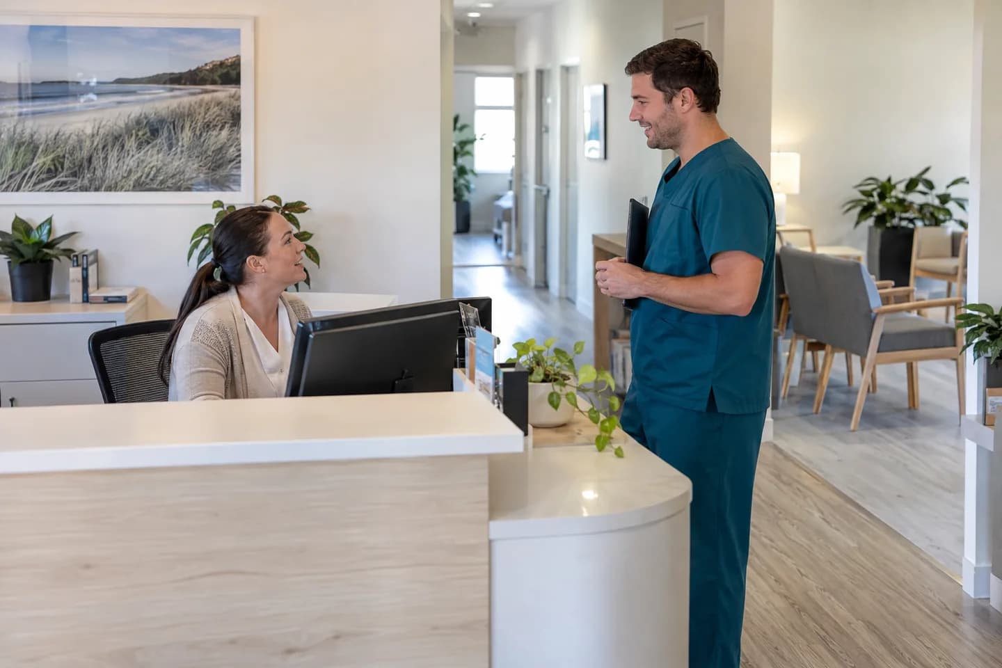 Receptionist and clinician coordinating work at an allied-health practice