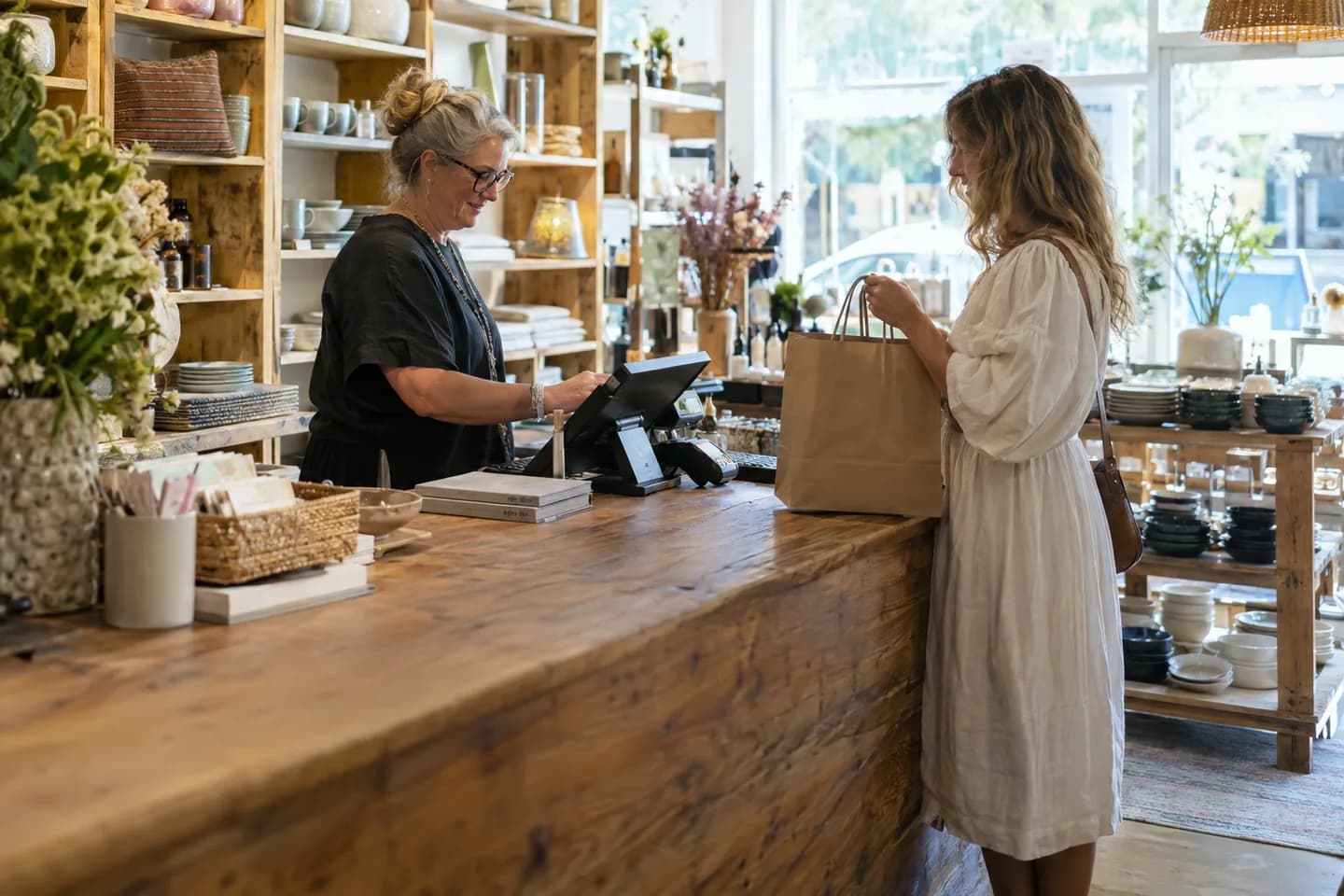 Shop owner processing a sale at a homewares store counter